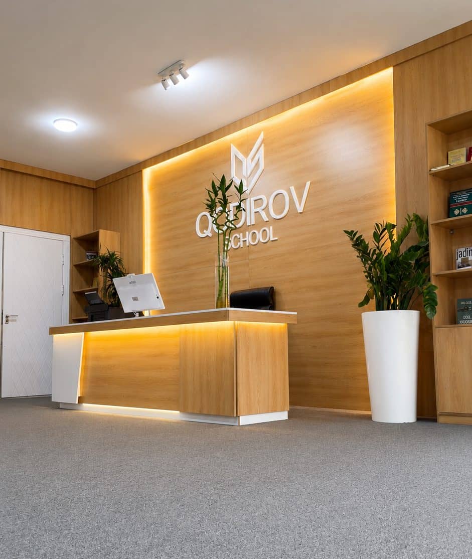 Qodirov School qabulxonasi — yog'och devor va maktab logotipi